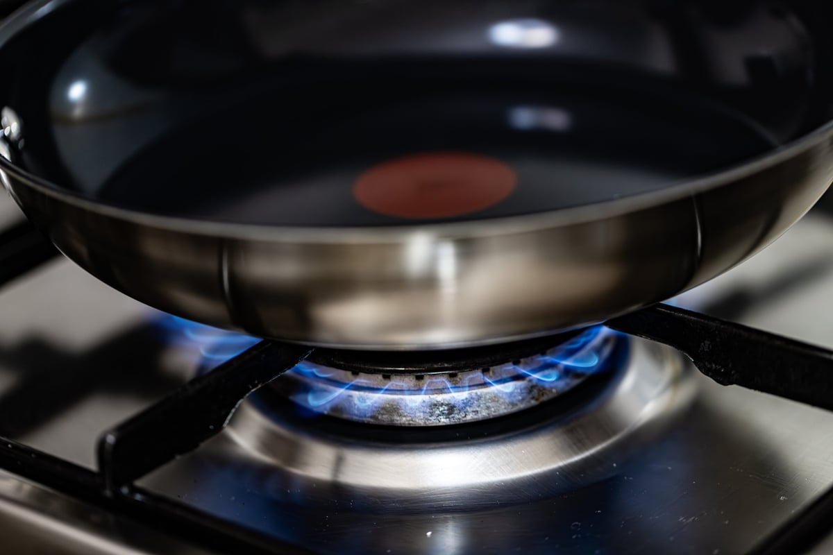 Tefal pan on a gas stove with blue flame